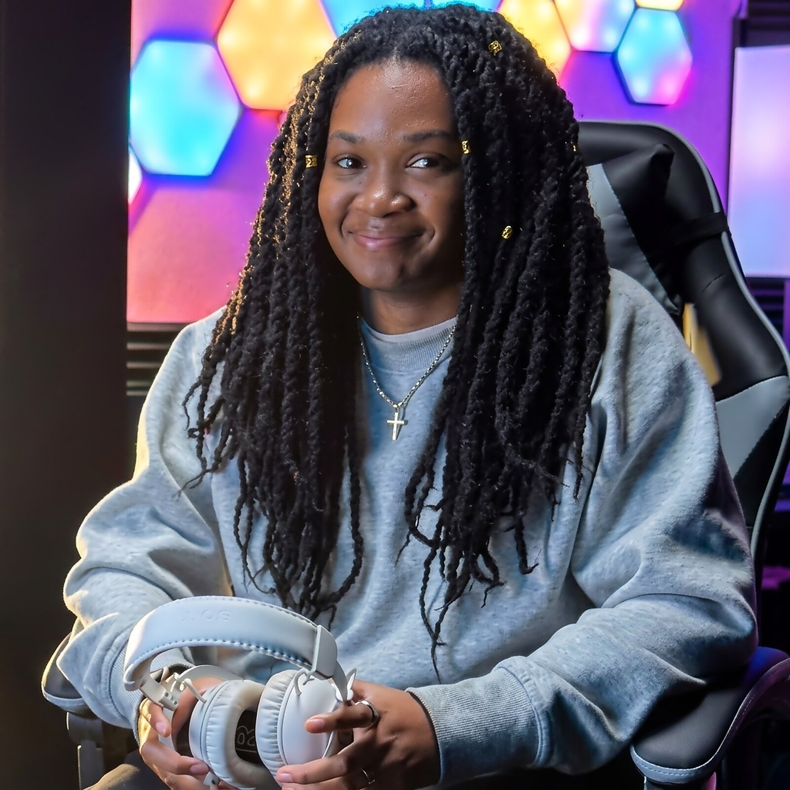 India “Alanis” Browne smiling in her gaming chair, holding a headset