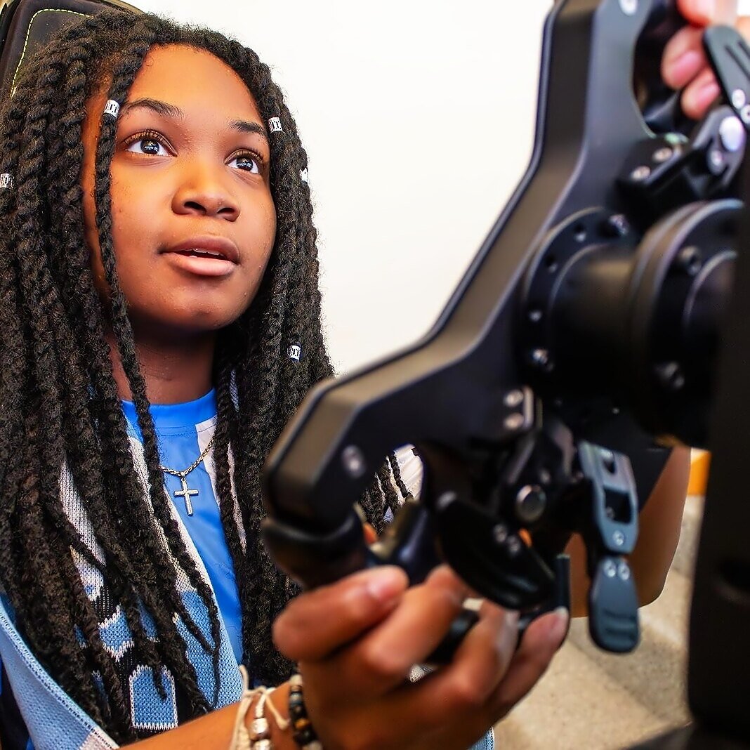 Alanis concentrating at a racing simulator controller